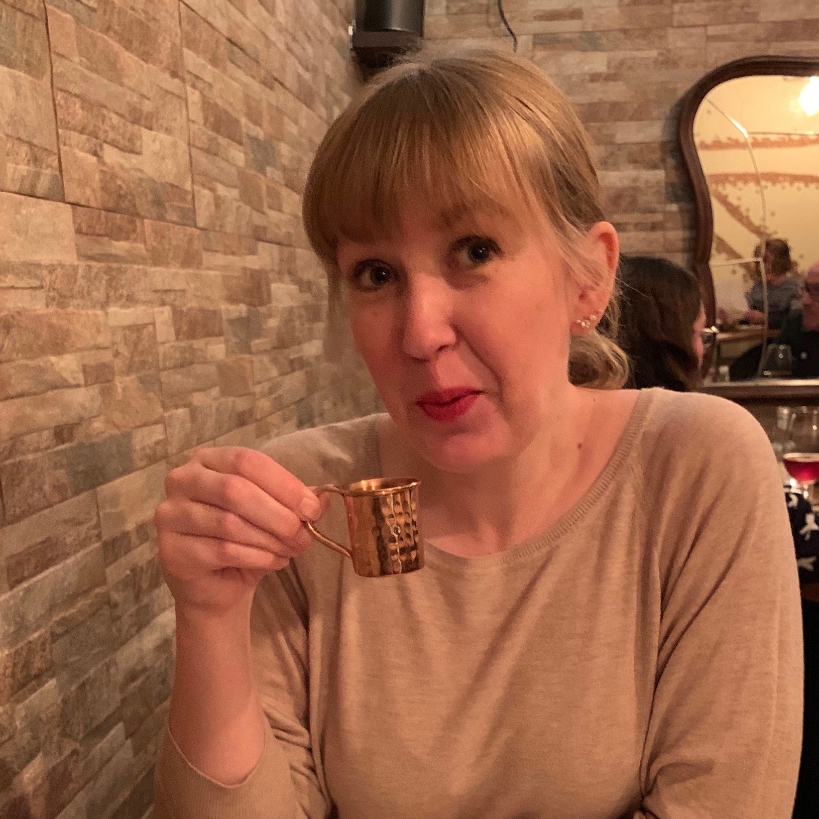 emily drinking mulled wine from a tiny cup
